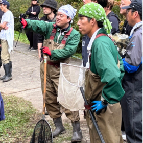 相葉ヒロミのお困りですカー？の草津のロケで池の視察を行うNPO birth自然環境マネジメント部の金本と山下